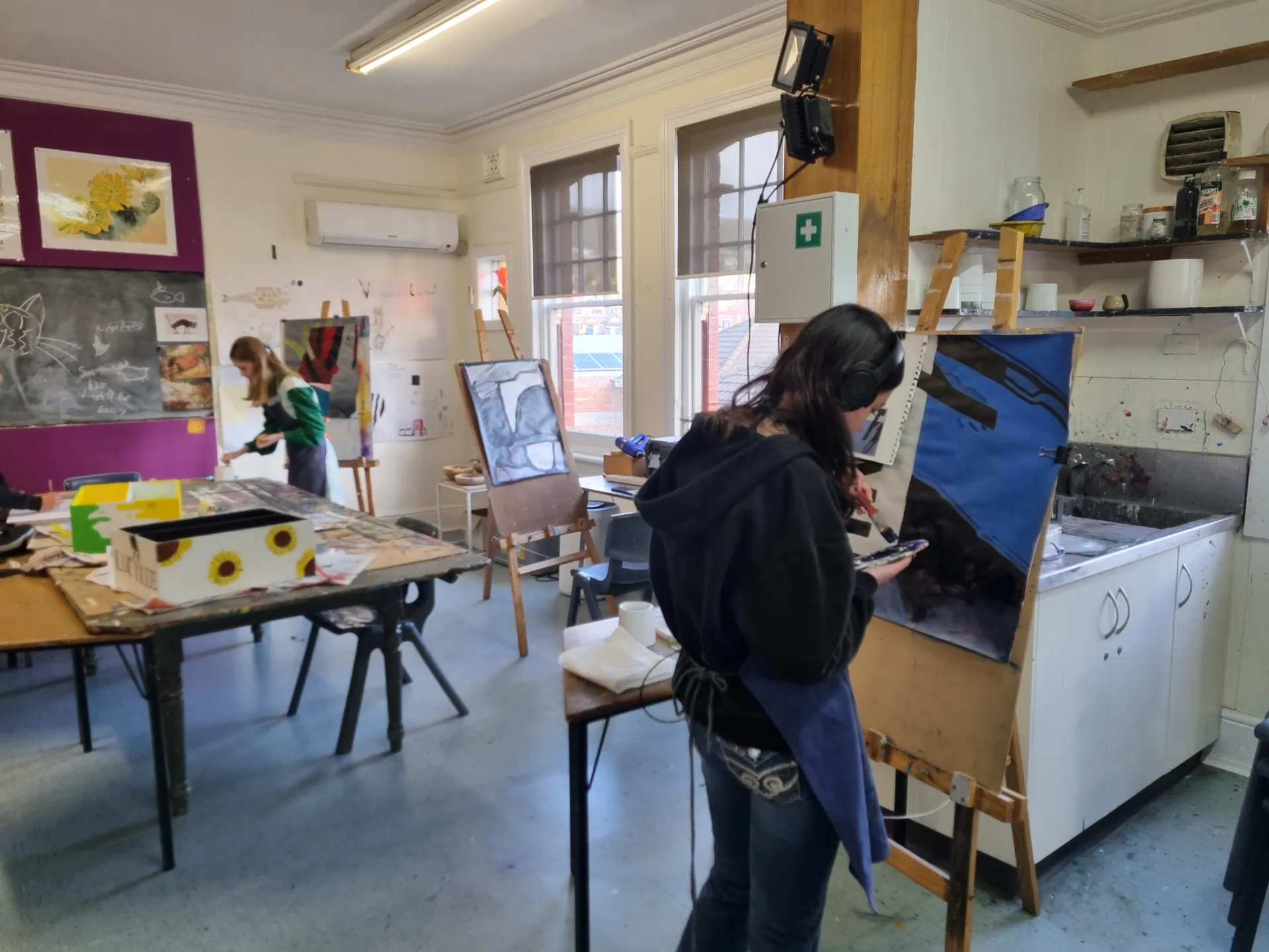 Student painting at an easel