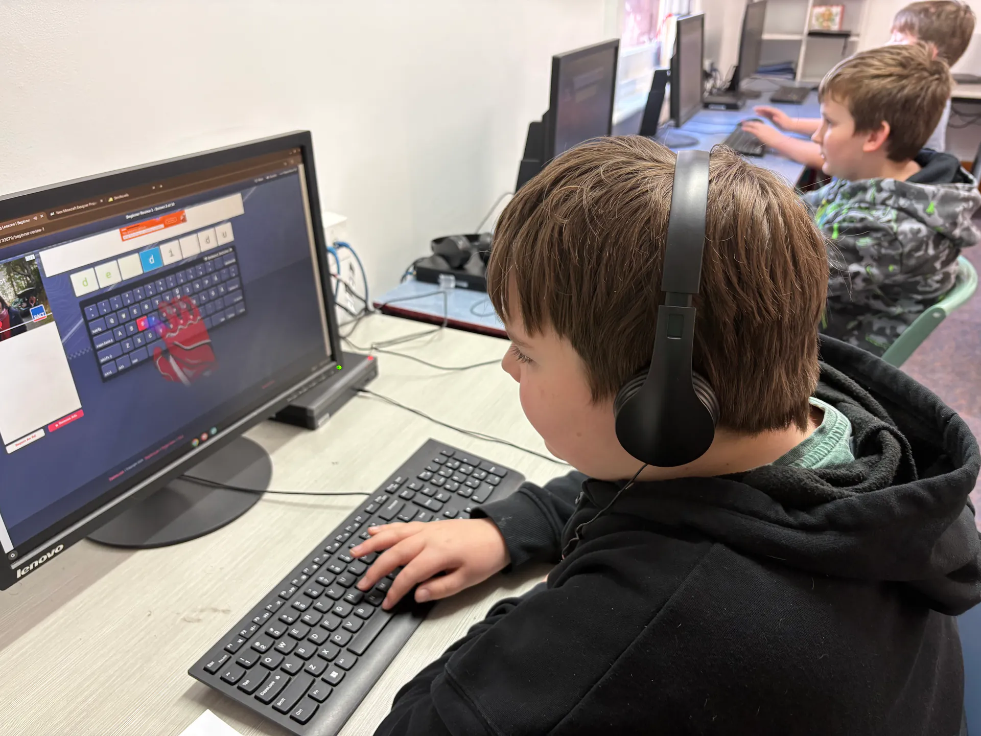Student using a computer and headphones for digital learning